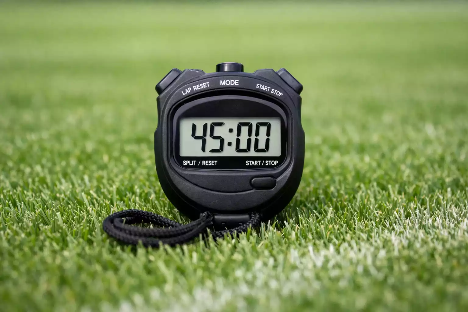 Cronómetro de árbitro sobre césped de campo de fútbol profesional